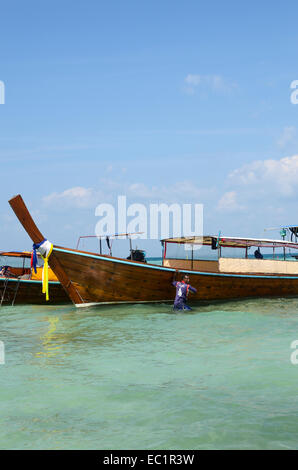 Longtail Touristenboot mit Thai Seemann im Meer, Koh Ngai, Thailand Stockfoto