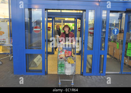 Eine Frau verlässt einen Lidl-Supermarkt Stockfoto