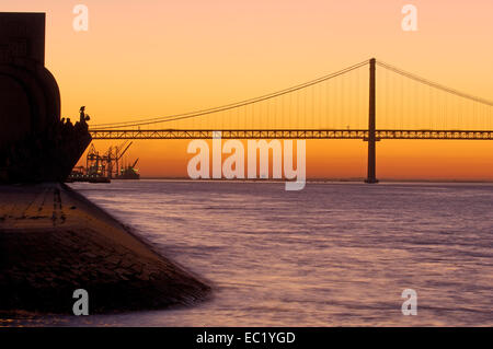 25 de Abril Brücke, Ponte 25 de Abril, 25. April Bridge und Denkmal der Entdeckungen, im Morgengrauen, Tejo, Tejo-Fluss Stockfoto