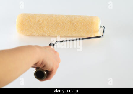 Weibliche Handmalerei mit Walze auf weiße Fläche (selektiven Fokus, Fokus auf der Vorderseite der Walze) Stockfoto