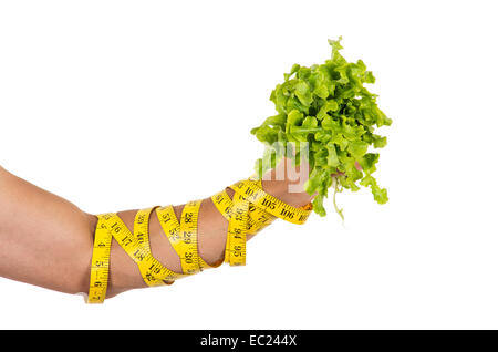 Mannes Arm gewickelt in Maßband mit frischen Salatblättern Stockfoto