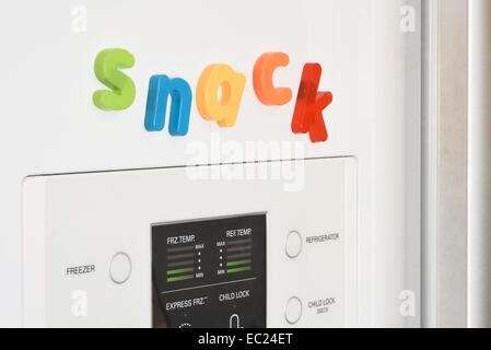 Das Wort "Snack" ausgeschrieben im Kühlschrank-Magnete an der Tür des Kühlschranks. Stockfoto