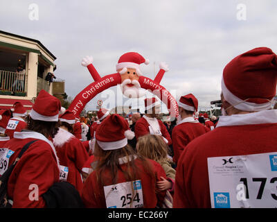 Menschen in Santa passt warten auf Beginn der Charity Santa run auf das Weihnachtsfest von Padstow, Cornwall, UK Stockfoto