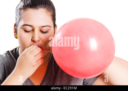 indische übergewichtige Dame bläst Ballon Stockfoto