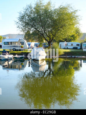 Campingplatz am See mit Wohnwagen und Boote Stockfoto