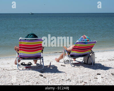 Strandbesucher in Side-by-Side Stühle auf Tigertail Beach, Marco Island, Florida, USA, 9. Oktober 2014, © Katharine Andriotis Stockfoto