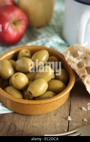 Piment gefüllte Oliven in eine rustikale Mahlzeit-Einstellung.  Selektiven Fokus auf vorderen Oliven. Stockfoto