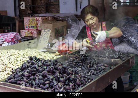 NEW TAIPEI CITY, TAIPEI, TAIWAN. 2. NOVEMBER 2014. Taiwanesische Hersteller Vorbereitung Wasserkastanien auf einem Straßenmarkt in Taiwan, Stockfoto