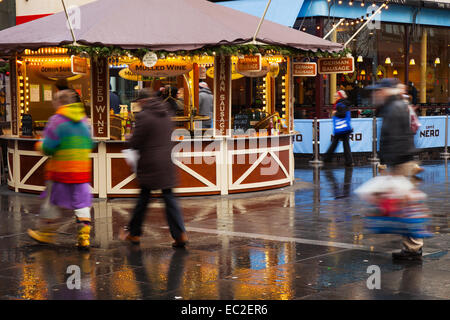 Einzelhändler verkaufen Glühwein und Würstchen in der Chapel Street, Southport, Merseyside, UK nasses Wetter. Nach dem Gewitter in den frühen Stunden des Küstenortes hält Wind, Regen und Hagel, mit zeitweiligem Sonnenschein. Stockfoto