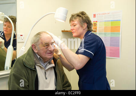 Eine NHS-Krankenschwester Untersuchung ein Patienten in einem medizinischen Zentrum-Zentrum Stockfoto