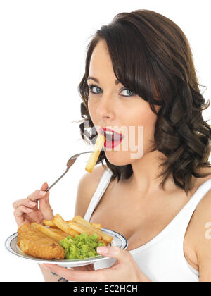 Glückliche junge Brunette kaukasische Frau Essen Traditionelle englische Fish und Chips essen mit Erbsenpüree, isoliert auf Weiss mit einen Freistellungspfad allein Stockfoto