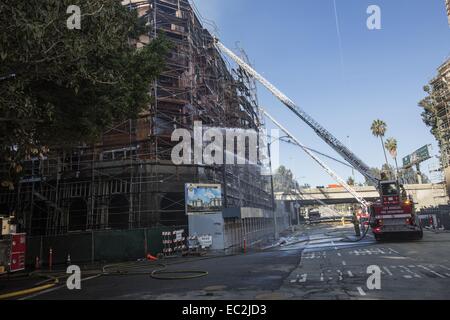 Los Angeles, Kalifornien, USA. 8. Dezember 2014. Feuerwehr Spritzwasser auf Hotspots nach einem massiven Brand entlang State Route 110, die eine Baustelle Mehrfamilienhaus nahe der Innenstadt von Los Angeles, Montag, 8. Dezember 2014 verschlungen. © Ringo Chiu/ZUMA Draht/Alamy Live-Nachrichten Stockfoto