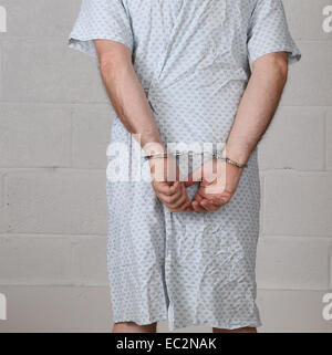 Ansicht von hinten von einem reifen Mann im Studio, in ein Krankenhemd Handschellen 6. Dezember 2014 Stockfoto