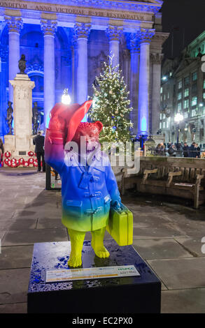 Bunte Statue von Paddington Bär Förderung der Film außerhalb der blau beleuchtete Royal Exchange, London, zugunsten der NSPCC, bei Nacht Stockfoto