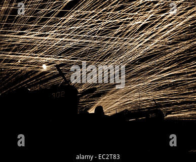 Japanische Nacht Räuber mit einer Lacework von anti-aircraft Feuer von der Marine Verteidiger der Flugplatz yontan, auf Okinawa. Im Vordergrund sind marine Corsair Kampfflugzeuge der Hölle Belles' Squadron. 1945. Stockfoto