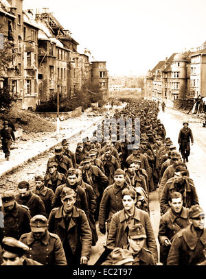 Die endlose Prozession von deutschen Gefangenen mit dem Fall von Aachen marschieren durch die zerstörte Stadt Straßen in Gefangenschaft. Deutschland, Oktober 1944. Stockfoto