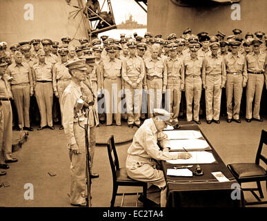 Gen.douglas Macarthur Zeichen als Oberster Alliierter Befehlshaber während der formalen Übergabe Zeremonien auf der USS Missouri in der Bucht von Tokio. Hinter gen.MACARTHUR SIND LT.gen.Jonathan Wainwright und Lt.gen.a. e. percival. 2. september 1945. Lt. c. w. Wheeler. (Marine) Stockfoto