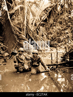 Sgt. Carl weinke und Pfc. Ernest Majoran, Signal Corps Kameraleute, waten durch Strom beim nachfolgenden Infanterie Truppen im vorderen Bereich während der Invasion an einem Strand in Neuguinea. Red Beach 2, tanahmerah. April 22, 1944. Stockfoto