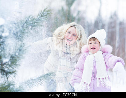 Glücklich Mopther und Kind spielt mit Schnee im Winter im freien Stockfoto