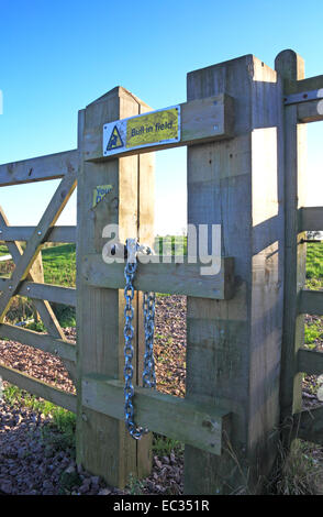 Ein Vorhängeschloss und Kette mit einem Stier im Feld Mitteilung über einen Holzzaun. Stockfoto