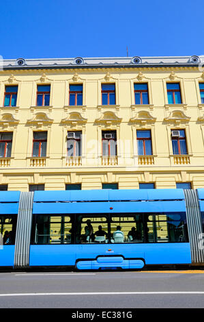 Zagreb, Kroatien. Moderne Straßenbahn vorbei an einem alten Gebäude Stockfoto