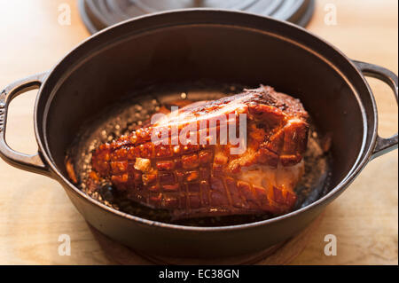 Schweinebraten Sie mit Kruste in einem Schmortopf aus Gusseisen Stockfoto