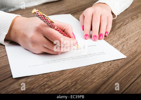 Die Geschäftsfrau Hand mit Stift, die Unterzeichnung eines Vertrages. Stockfoto