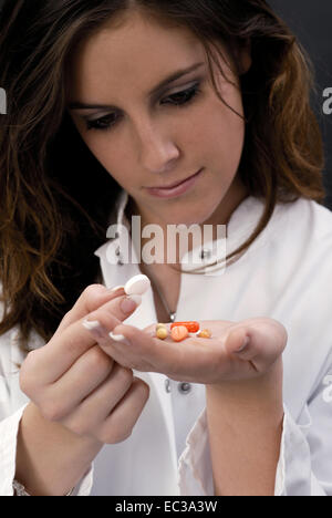 Frau Doktor Controlling Pillen in der Hand Stockfoto