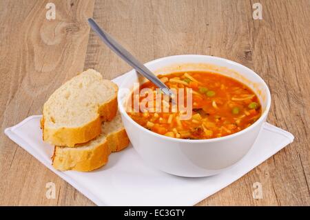 Hausgemachte vegetarische Minestrone-Suppe mit Brot serviert. Stockfoto