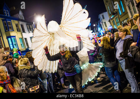 Eine Frau, die eine riesige weiße Taube des Friedens führt ein Laternenumzug durch Einschalten der 2014 im Vorfeld Aberystwyth Weihnachtslichter, Wales UK Stockfoto