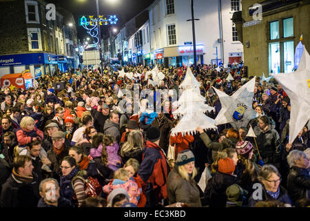 Massen von Menschen auf eine Laterne Prozession durch Aberystwyth Straßen vor Einschalten der 2014 Weihnachtslichter, Wales UK Stockfoto