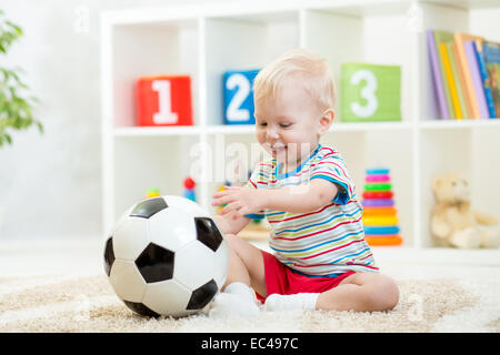 Kid Boy mit Fußball indoor Stockfoto