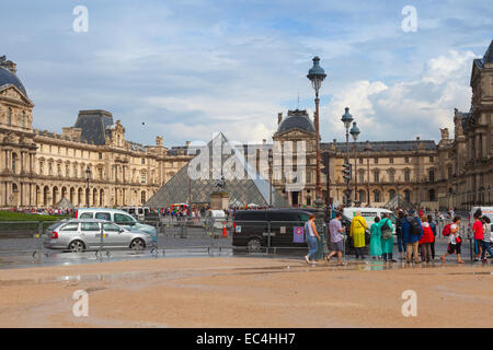 Paris, Frankreich - 7. August 2014: Fassade des Louvre Museums mit Touristen und Autos fahren auf der Straße, Paris Stockfoto