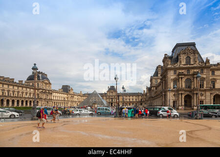 Paris, Frankreich - 7. August 2014: Fassade des Louvre Museums mit Touristen auf der Straße, Paris Stockfoto