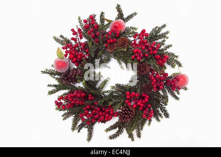 Feste, religiöse, Weihnachten, Kranz aus künstlichen Blätter und Beeren mit Tannenzapfen und Äpfel. Stockfoto