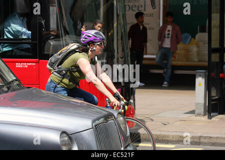 Eine weibliche Radfahrer unterwegs unter Verkehr in der Oxford Street, London Stockfoto