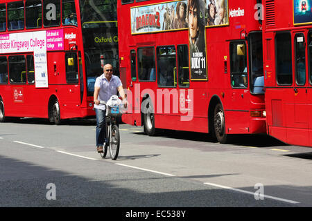 Ein Radfahrer unterwegs übergeben eine Warteschlange von Bussen in London Stockfoto