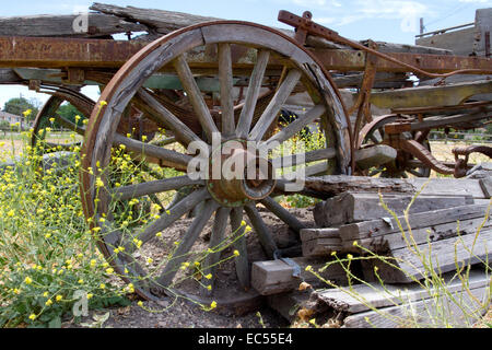 Altes Wagenrad auf Wagen Rahmen auf dem Display in einem Feld in Los Alamos, Kalifornien, USA im Juli Stockfoto