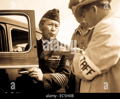 Gekleidet in Uniform Kennzeichnung Dienst im ersten Weltkrieg, tritt dieser Veteran Santa Anita Park-Montage-Zentrum für Personen japanischer Abstammung von der Westküste evakuiert.  Arcadia, CA.   5. April 1942.  Foto von Dorothea Lange. Stockfoto