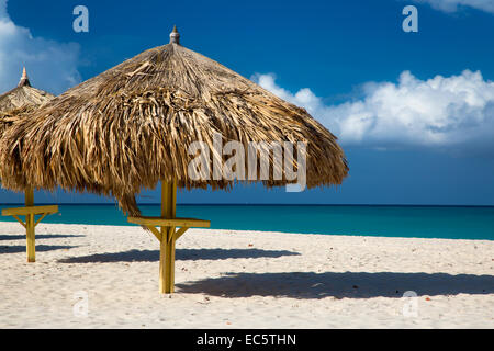 Grass Sonnenschirme am weißen Sandstrand am Eagle Beach, Aruba, West Indies Stockfoto