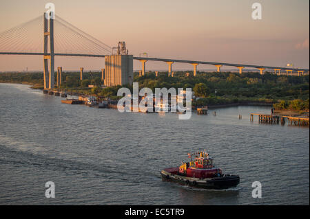 Lotsenboot in der Abenddämmerung am Savannah River mit Eugene Talmadge Memorial Bridge im Hintergrund. Stockfoto