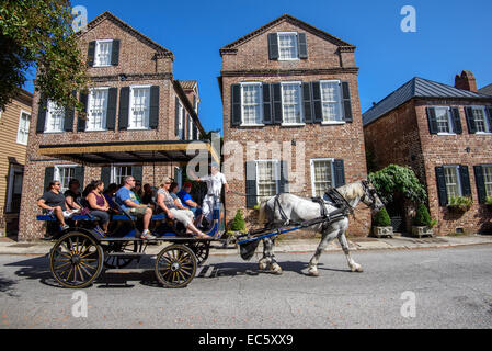 Pferdekutsche mit Touristen, die historische traditionelle Wohnarchitektur im French Quarter District von Charleston, SC. Genießen Stockfoto