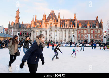 Menschen auf der Schlittschuhbahn auf dem Brügge-Weihnachtsmarkt auf dem Markt-Platz, Innenstadt von Brügge, Belgien-Europa Stockfoto