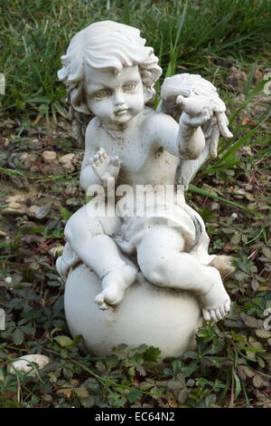 Kleine weiße Engelsstatue auf dem Friedhof-Boden Stockfoto