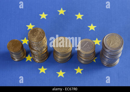 Euro-Münzen vor der europäischen Flagge Stockfoto