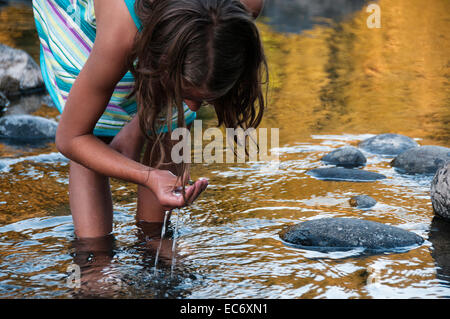 Ein Mädchen sammeln Flusssteine Stockfoto