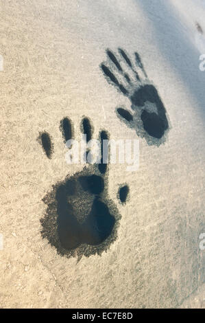 Hand wie Foot print druckt geschmolzene Frost auf Fenster Auto Idee gefangen im Inneren Überlebenden Kältewelle fordert Hilfe Sonnenaufgang Stockfoto