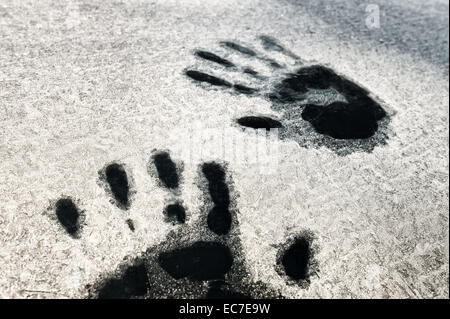 Hand wie Foot print druckt geschmolzene Frost auf Fenster Auto Idee gefangen im Inneren Überlebenden Kältewelle fordert Hilfe Sonnenaufgang Stockfoto