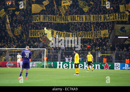 Dortmund, Deutschland. 9. Dezember 2014. Dortmund Fans halten, bis ein Banner, der liest "Auch internationale Zweisimmen Wir Eure Plätze Frei!" (lit.) "Wir halten auch international Ihre Sitze! Durchhalten - Sektion Stadionverbot! ") während der Champions League Gruppe D-Fußballspiel zwischen Borussia Dortmund und RSC Anderlecht im Signal Iduna Park in Dortmund, Deutschland, 9. Dezember 2014. Foto: MARIUS BECKER/Dpa/Alamy Live News Stockfoto