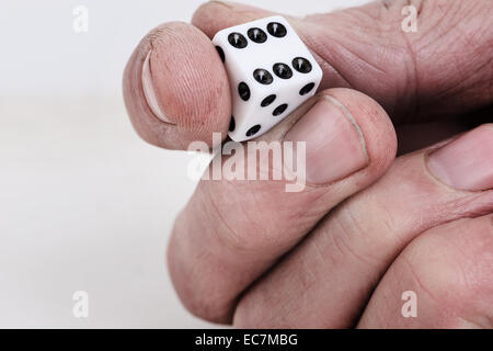 Würfel statt zwischen Finger und Daumen bereit, die ausgelöst werden, und das Schicksal der Wurf des Würfels gefunden Oberseite 6 Stockfoto